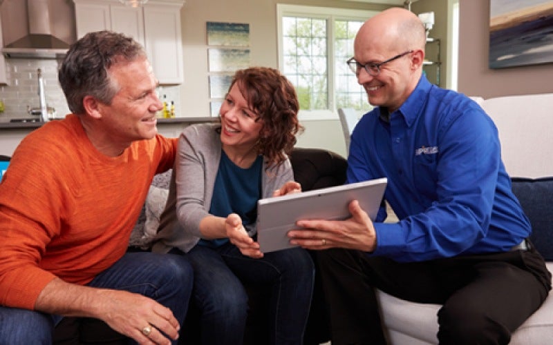 homeowners smiling with Empire flooring expert over flooring price