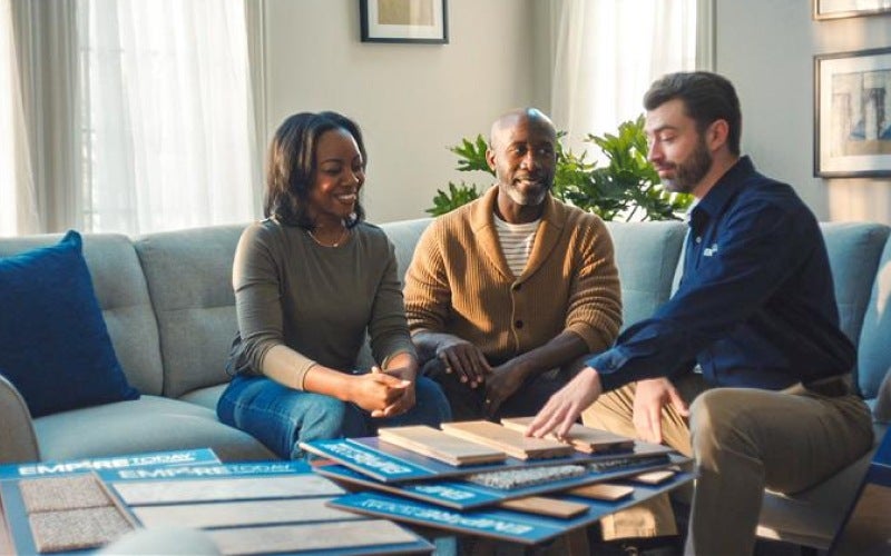 Empire flooring expert showing floor sample to homeowners